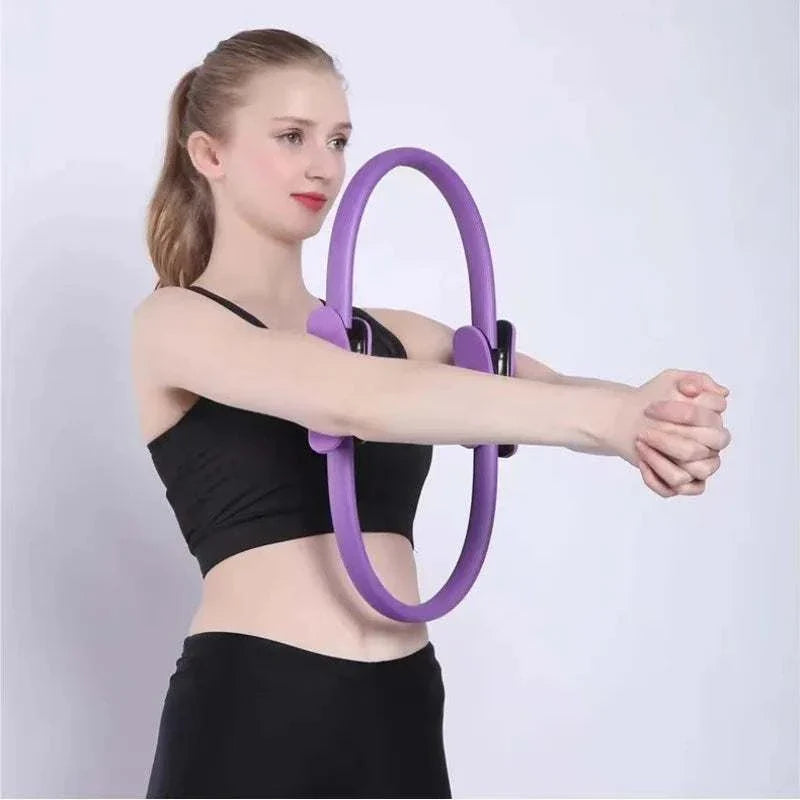 Woman using a purple Pilates Ring Magic Circle for arm exercise.